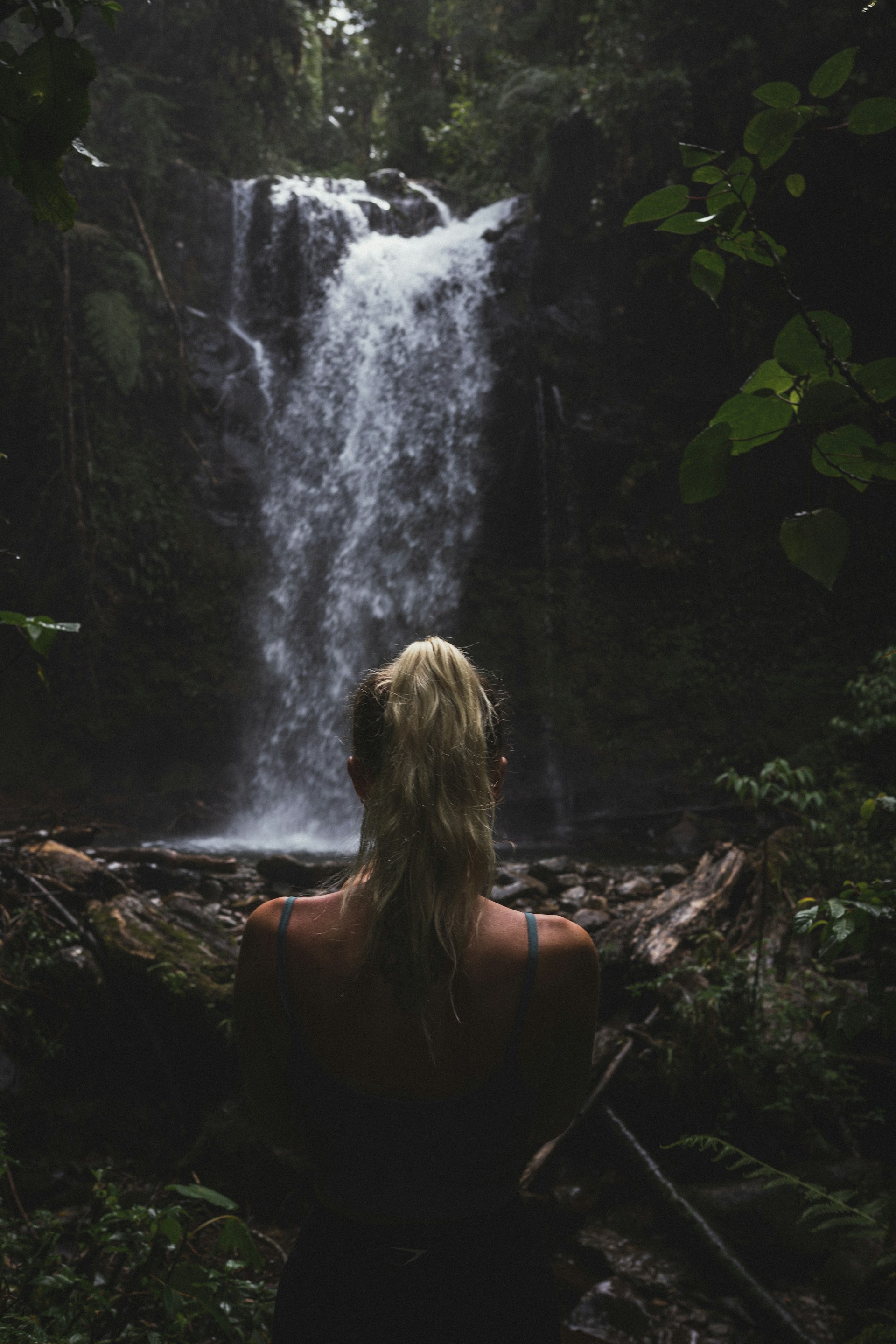 a woman standing in front of a waterfall