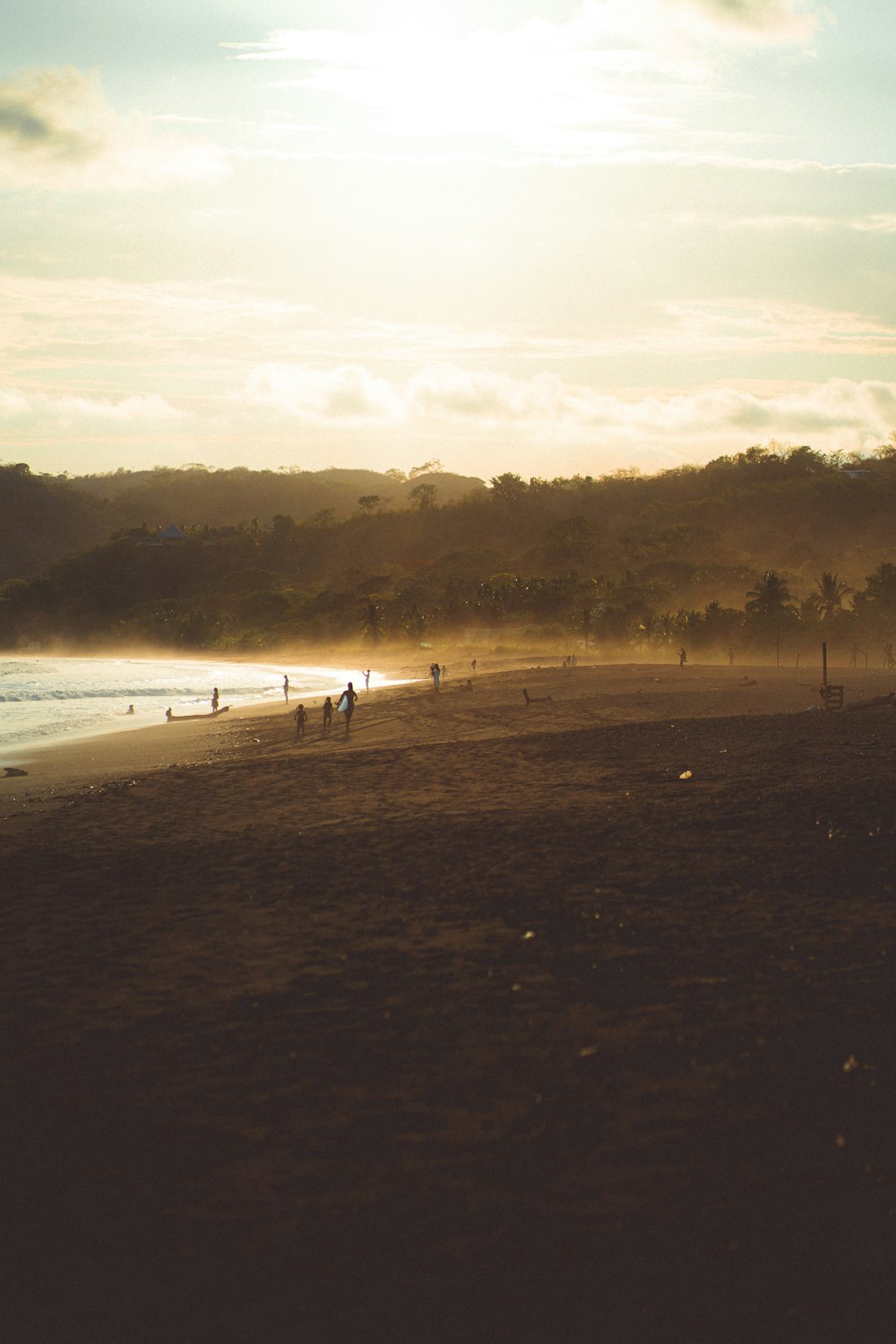 a group of people standing on top of a sandy beach