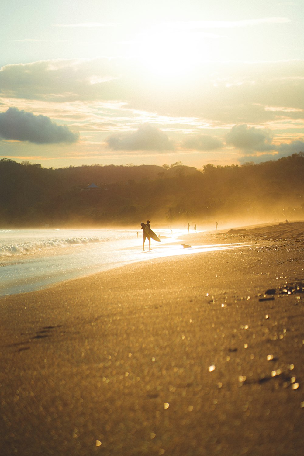 a person walking on a beach with a surfboard