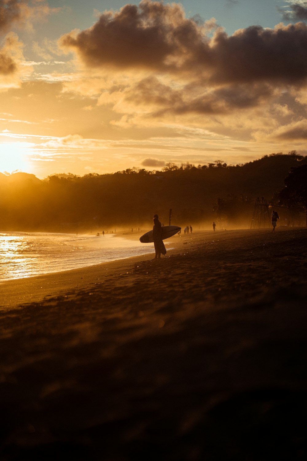 a person carrying a surfboard on a beach