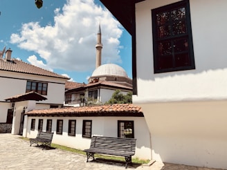 a white building with a black bench in front of it