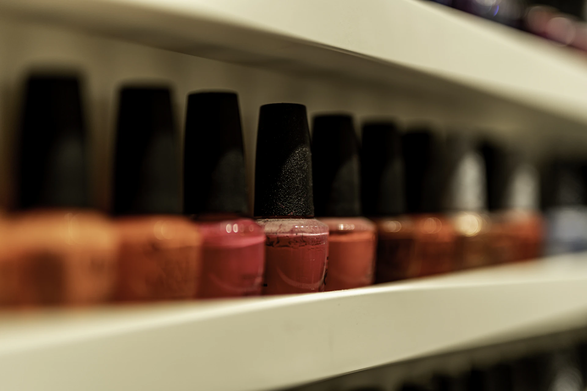 a row of bottles of nail polish on a shelf