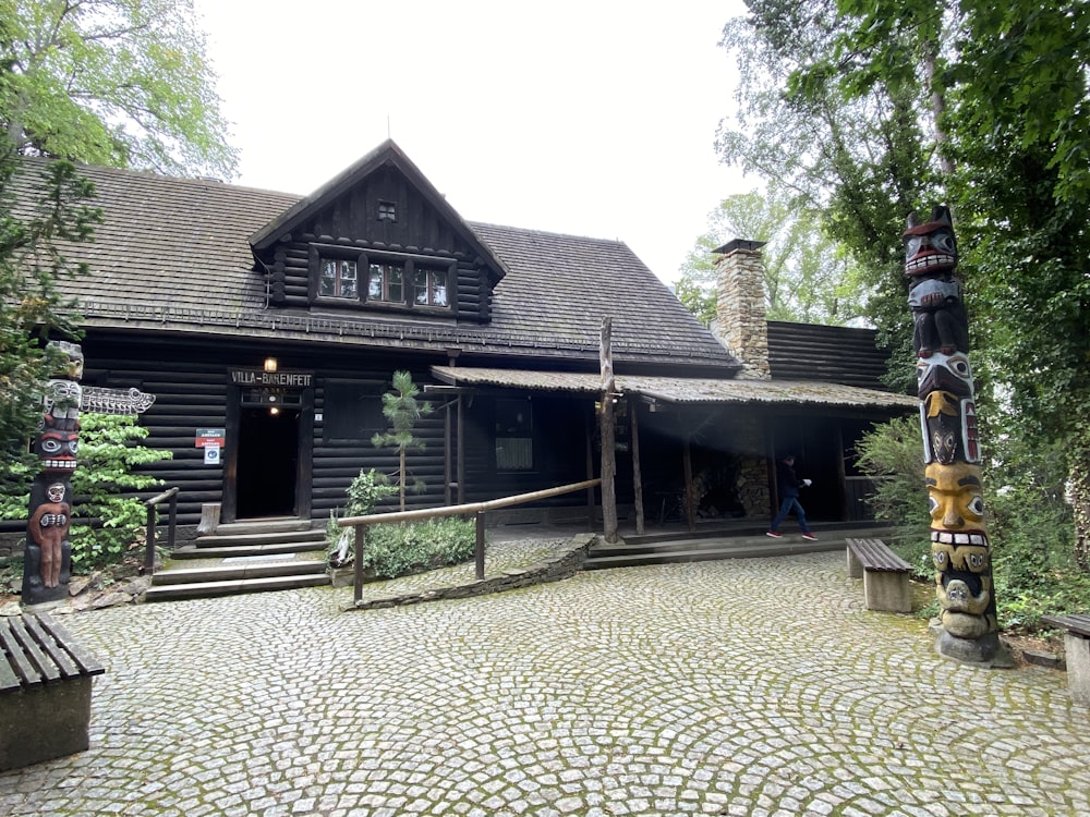 a log house with a totem pole in front of it