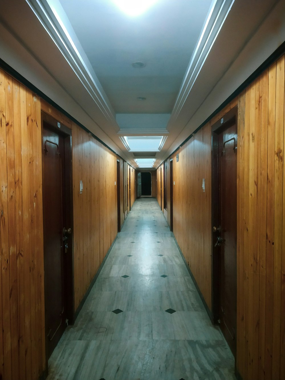 a long hallway with wooden walls and doors