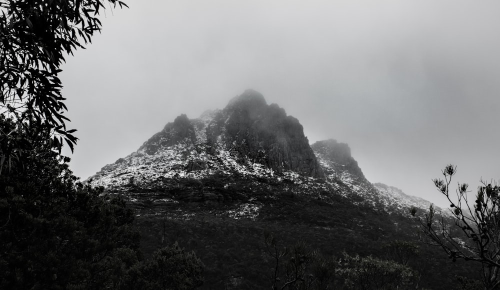 a black and white photo of a mountain covered in snow