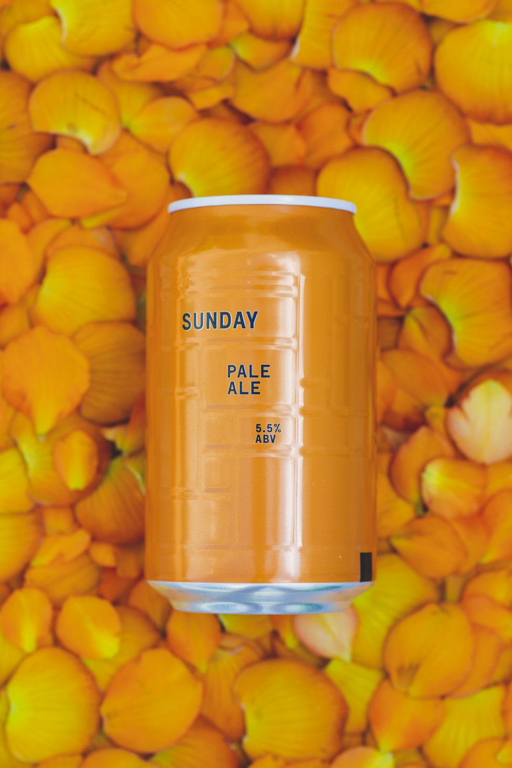 a can of pale ale on a bed of yellow flowers