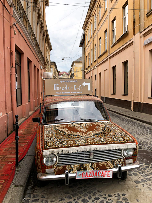 Compact economy car from Ardi Rental parked near a cozy seaside café in Golem
