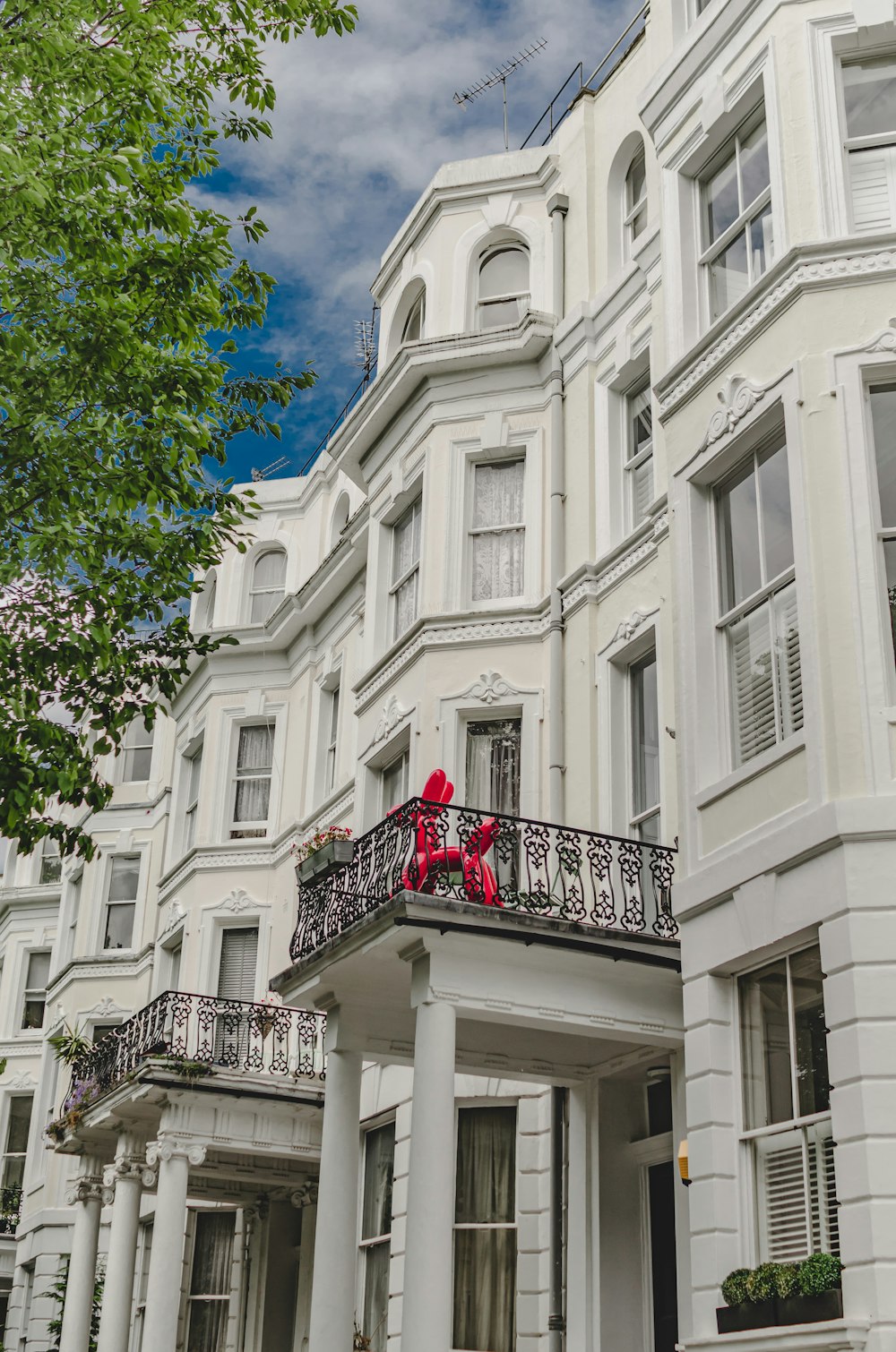 a large white building with a red teddy bear on the balcony