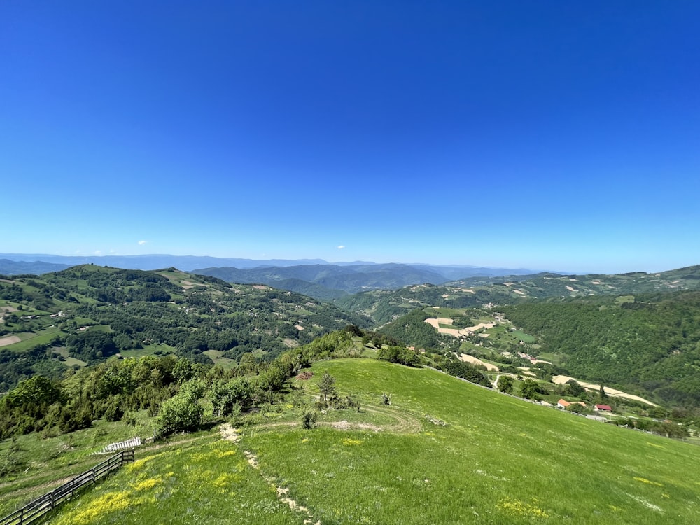 a view of a grassy hill with mountains in the background