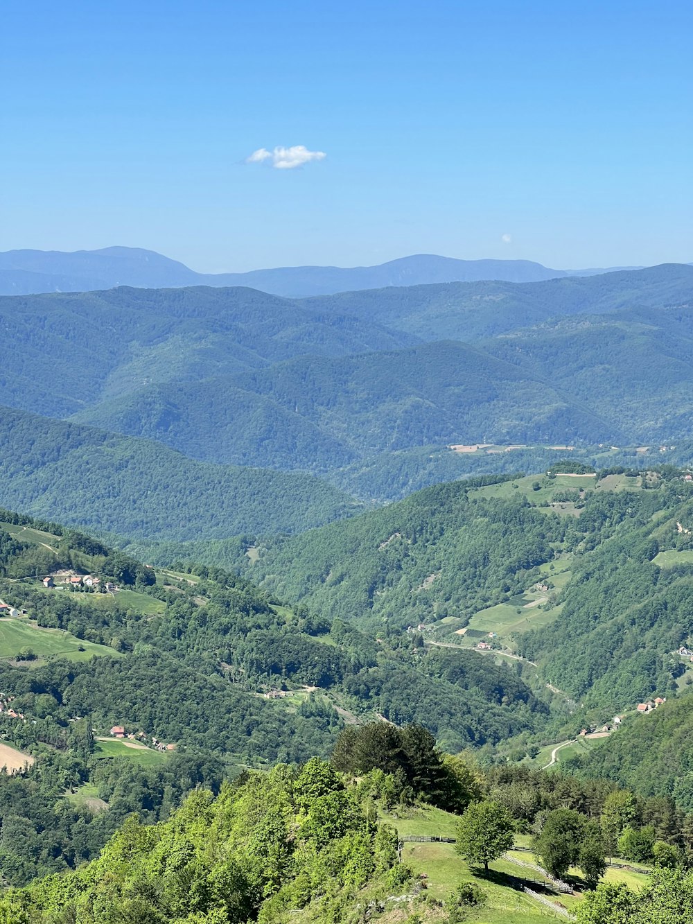 a scenic view of a valley with mountains in the background