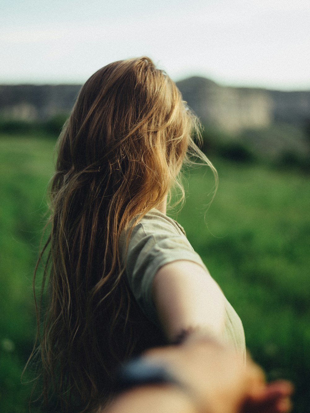 a woman is holding her hand out in a field