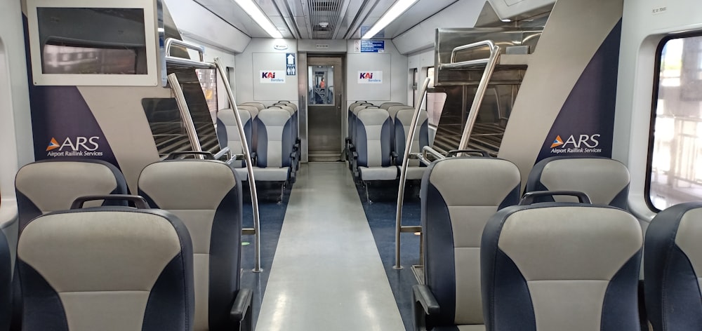 um vagão de trem vazio com assentos azuis e brancos