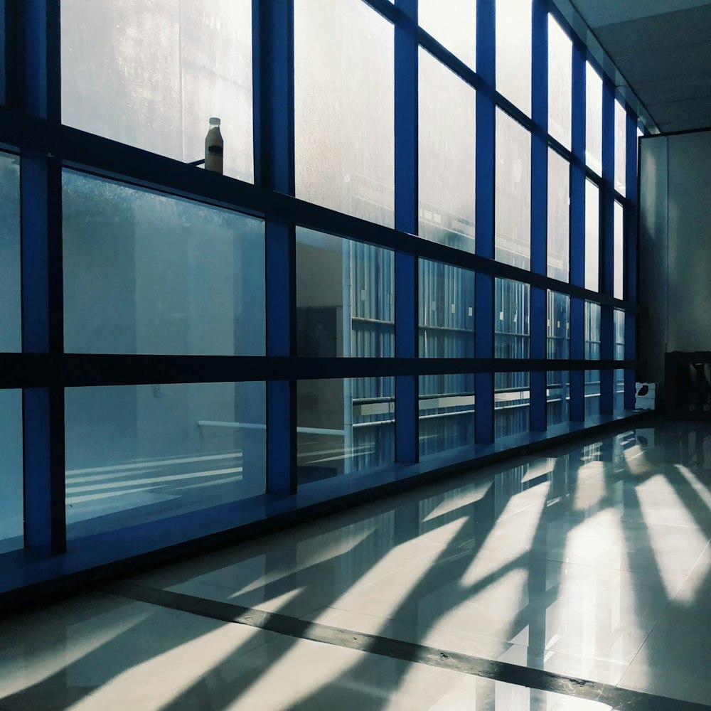 a long hallway with a large window and a clock on the wall