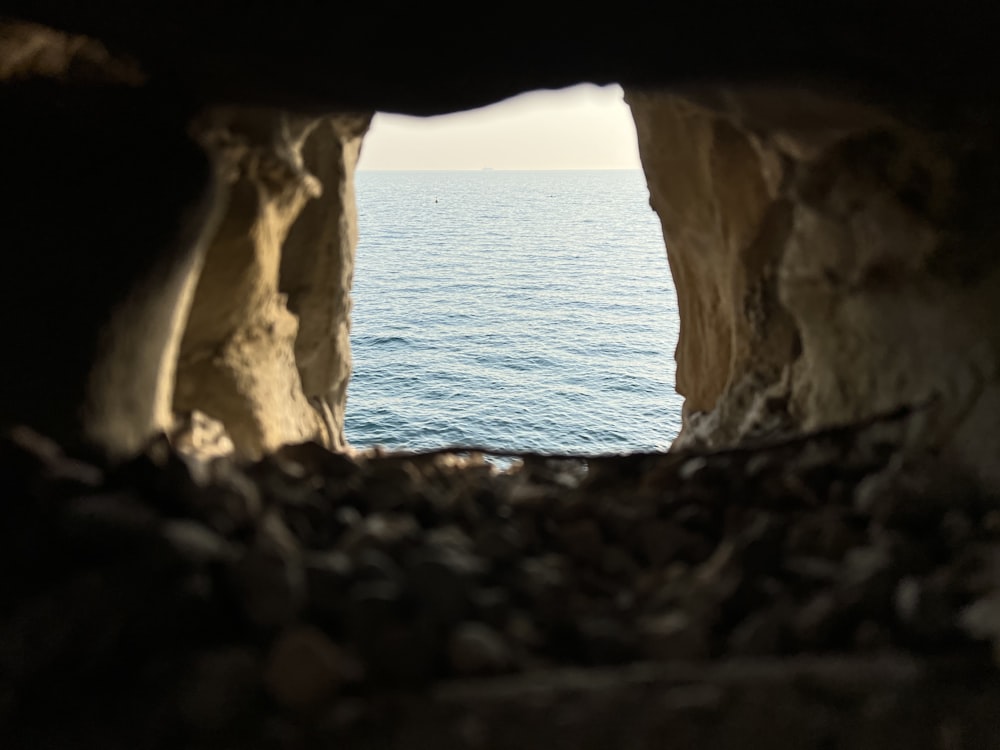 a view of a body of water through a cave