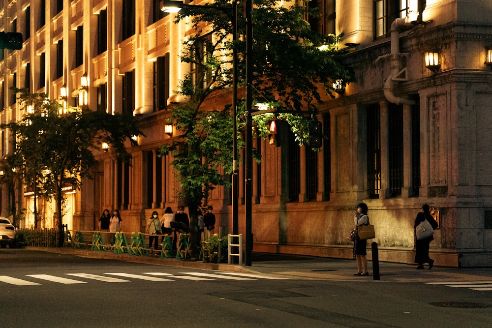 a group of people standing on the side of a street