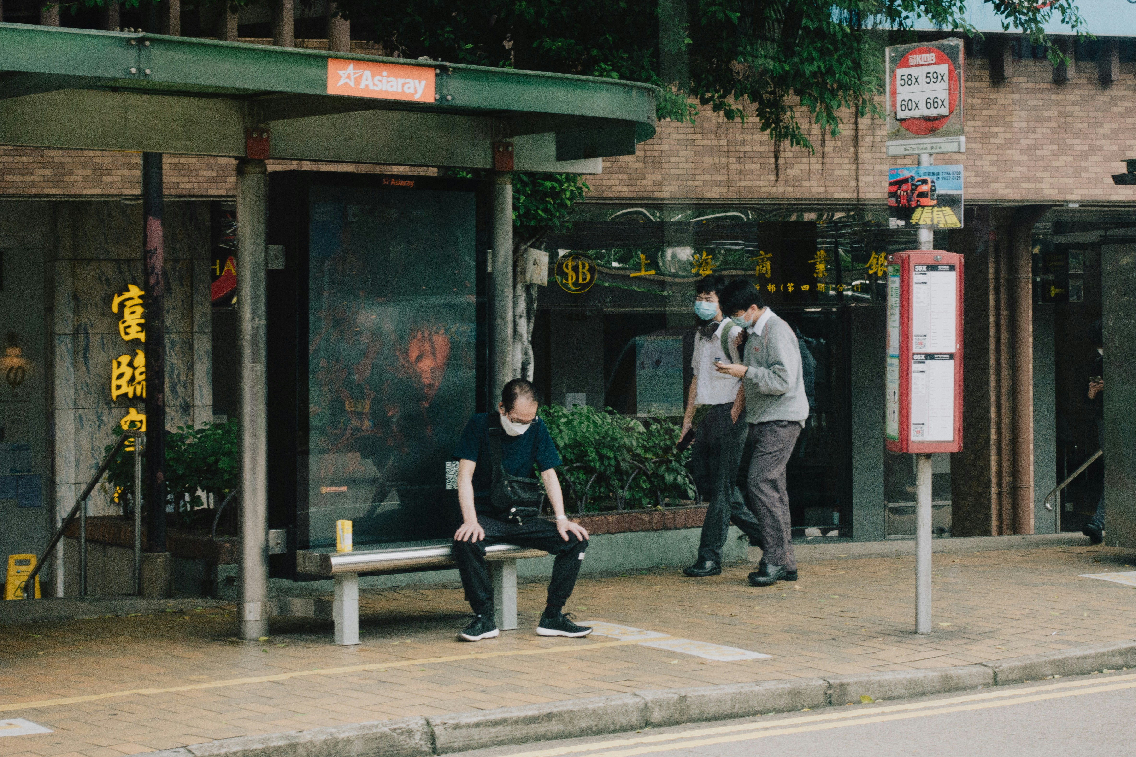 a man and a woman sitting on a bench in front of a building