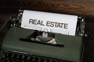 a close up of a typewriter with a real estate paper on it