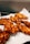 Crispy, golden-brown fried chicken pieces laid out on a white paper towel absorbing excess oil.