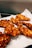 Crispy, golden-brown fried chicken pieces laid out on a white paper towel absorbing excess oil.