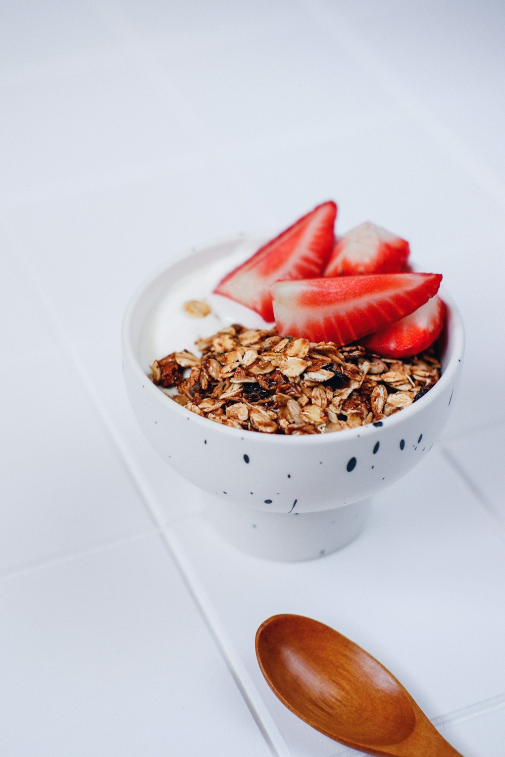 a bowl of granola with strawberries on top