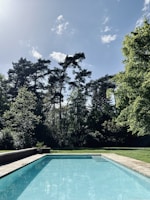 a swimming pool surrounded by trees and grass