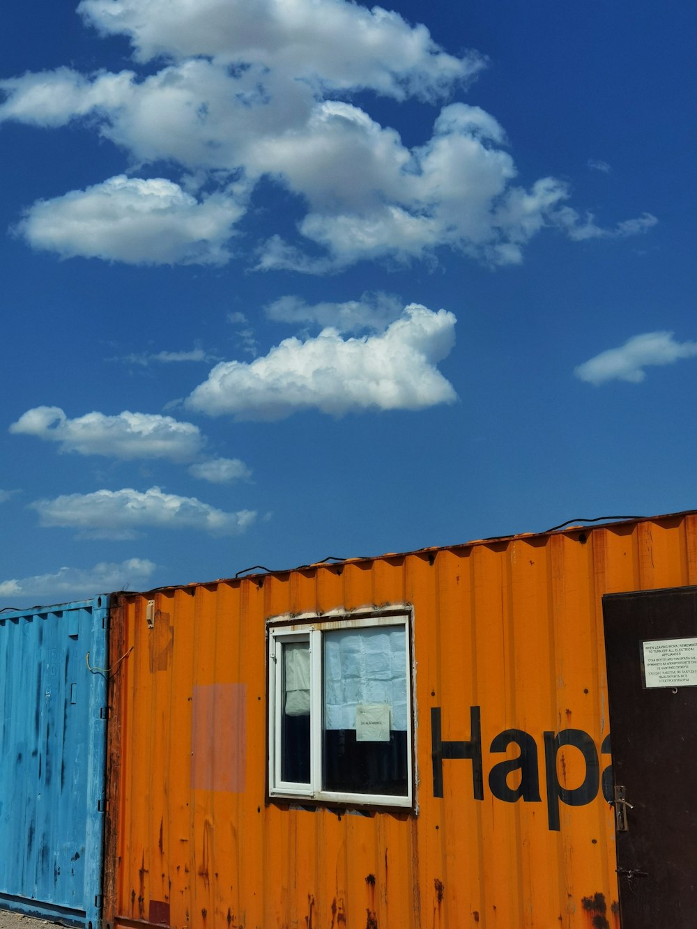an orange shipping container with the word happy painted on it