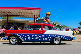 a red, white and blue car with a cowboy on top