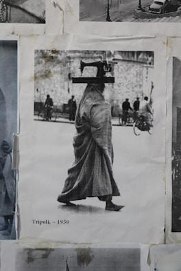 A black and white photograph of a person walking and carrying a sewing machine on their head. The person is wearing a long robe and is moving through a street scene with several people and bicycles in the background. The image is labeled 'Tripoli, ~1950' and is part of a collage.