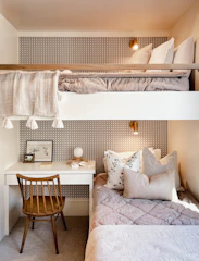 a bedroom with two bunk beds and a desk