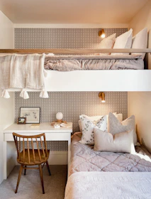 a bedroom with two bunk beds and a desk