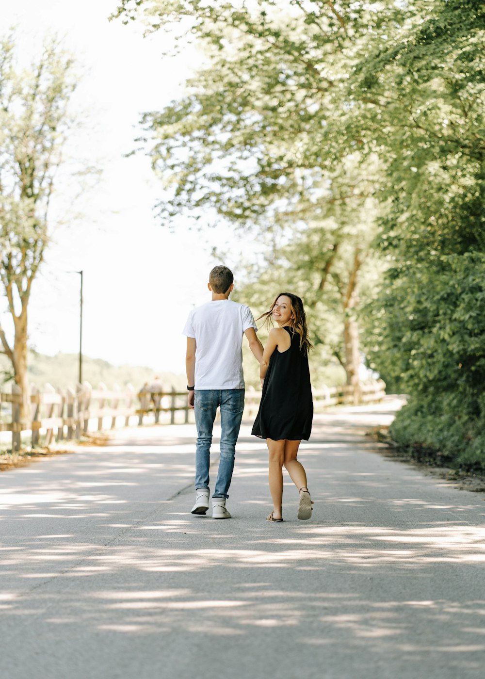 a man and a woman walking down a street holding hands