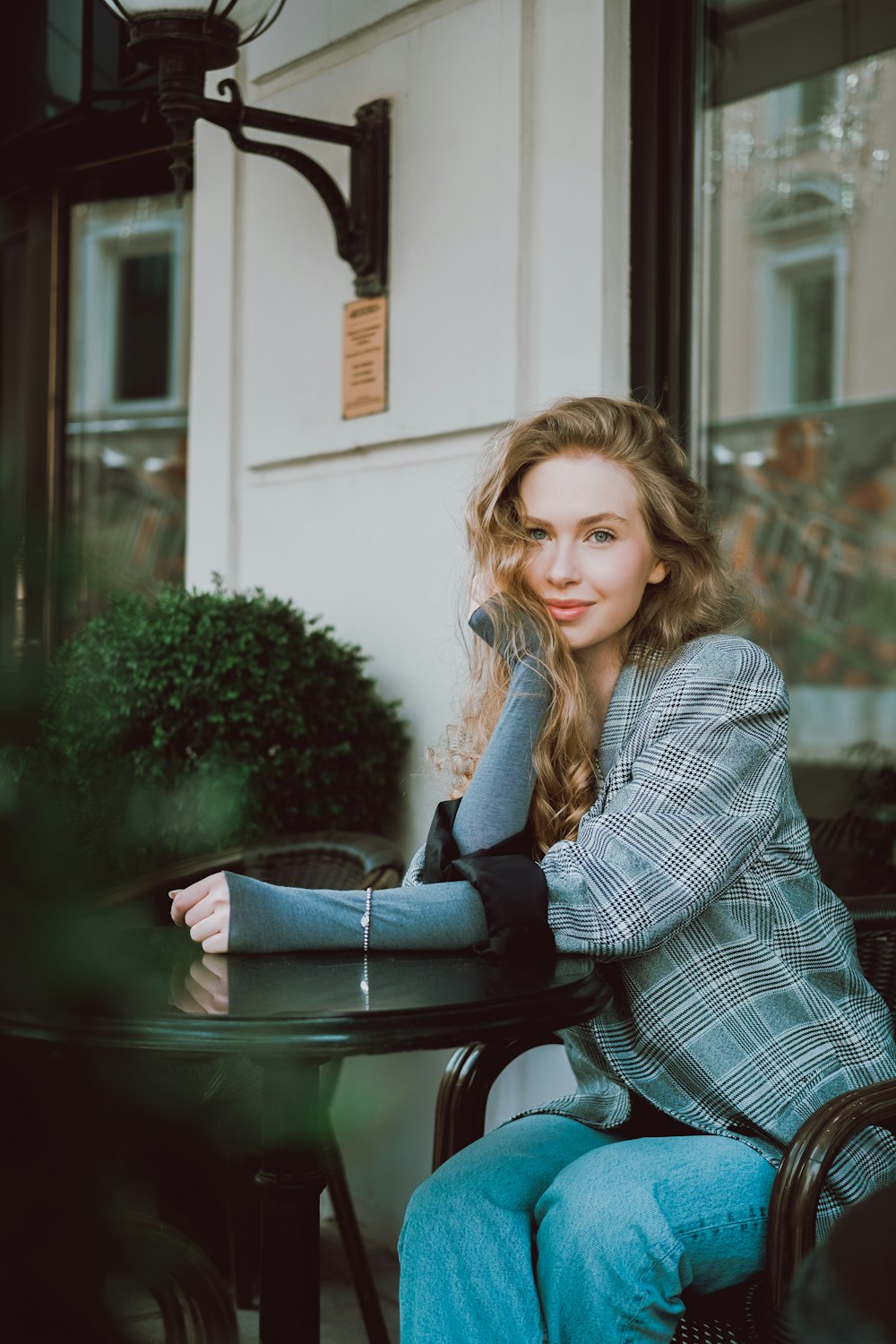 a woman is sitting at a table outside