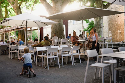 a group of people sitting at tables under umbrellas