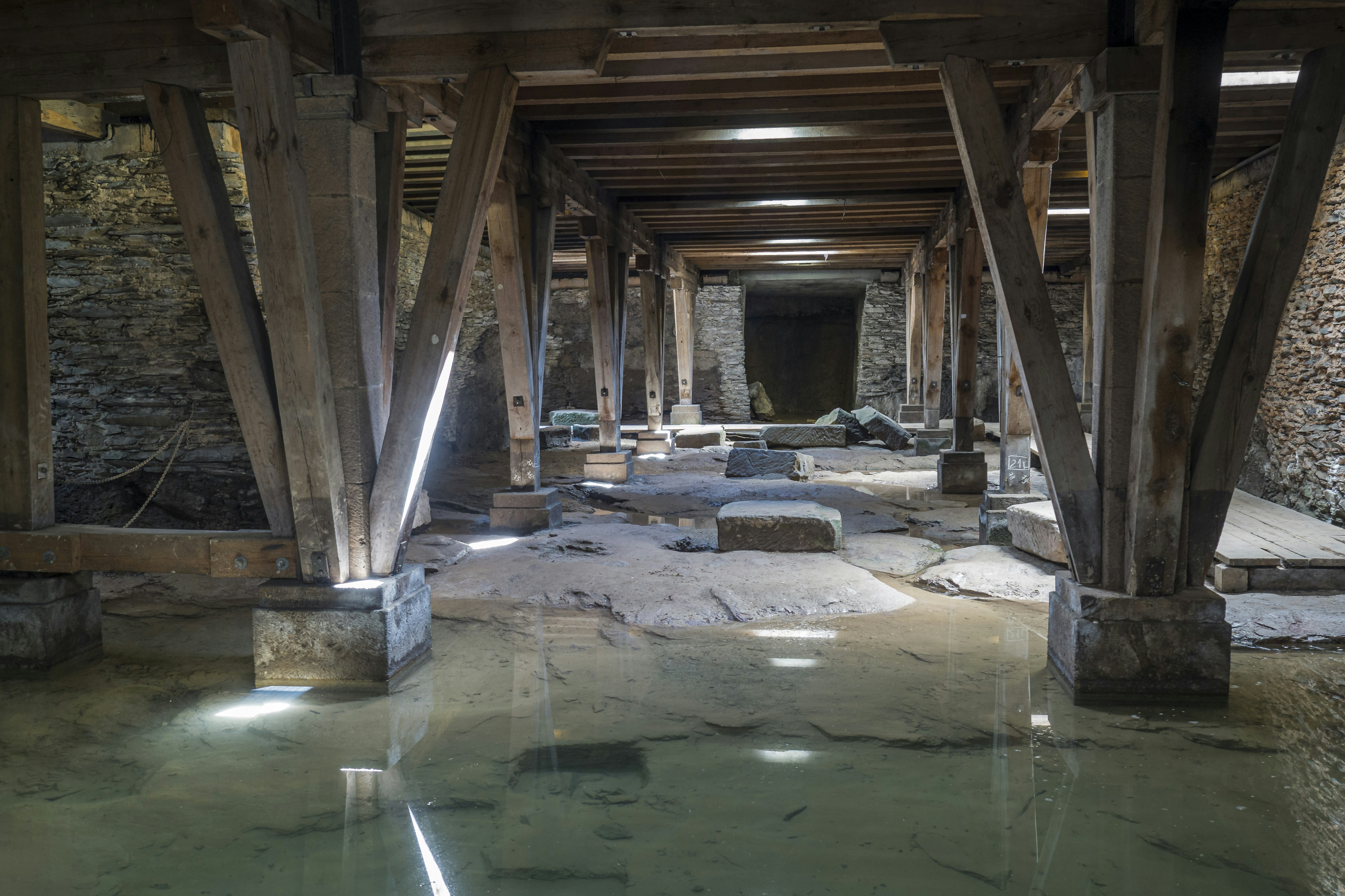 Interior of a commercial property with wooden beams, stone walls, and water on the floor, illustrating potential damage and the need for public adjuster services in insurance claims.