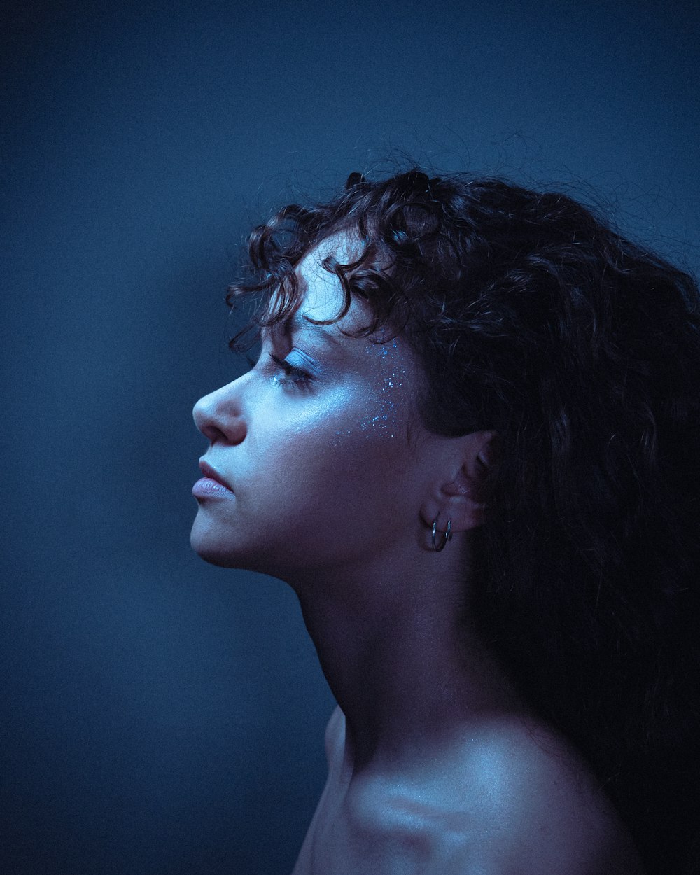 a woman with blue makeup and curly hair