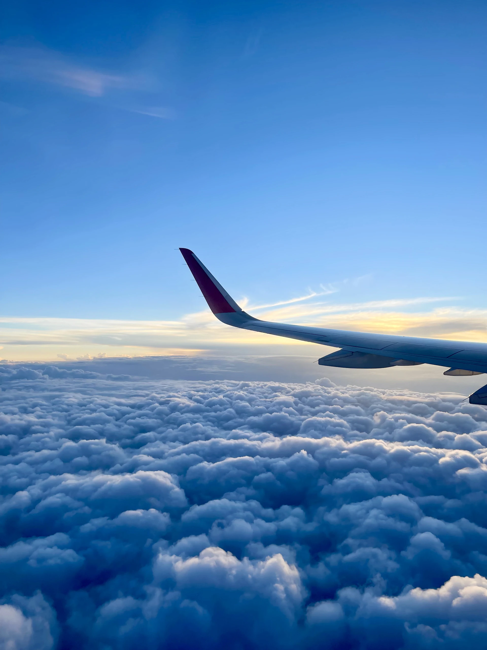 a view of the wing of an airplane above the clouds