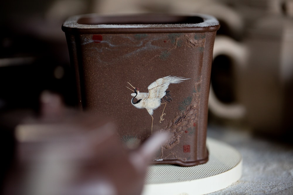 a close up of a cup with a bird on it