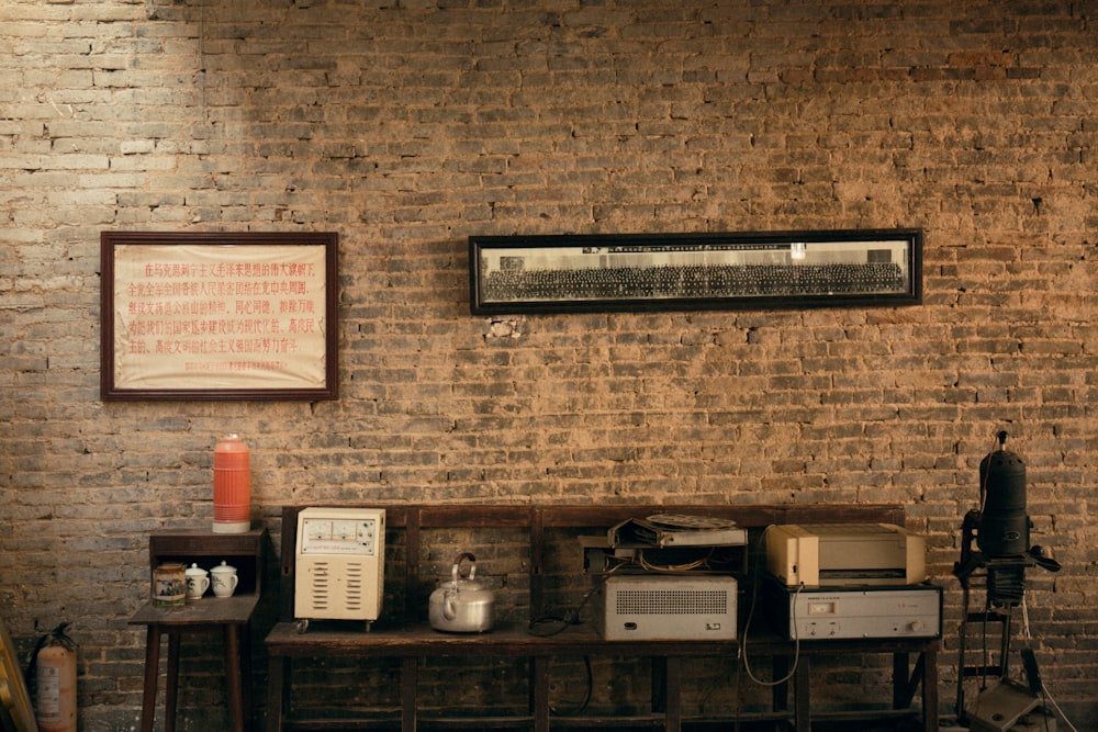 a room with a brick wall and a table with microwaves on it