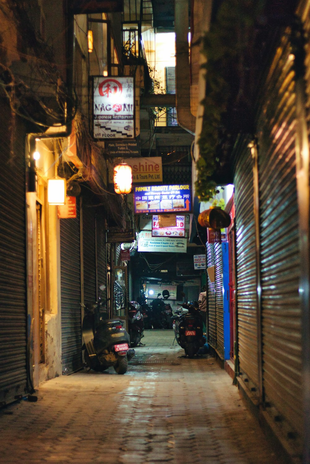 a narrow alley way with motorcycles parked on both sides