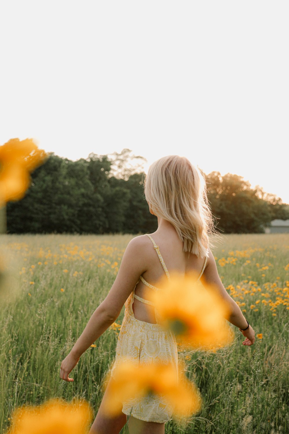 a woman standing in a field of yellow flowers