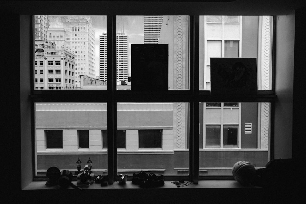 a black and white photo of a window with a view of a city