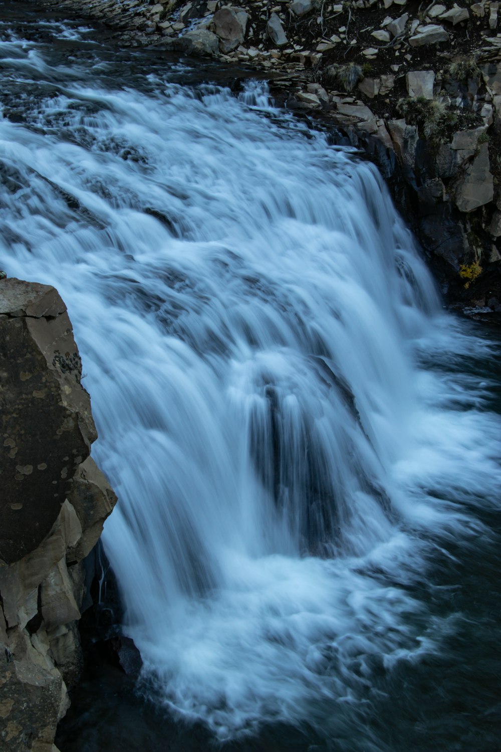 a small waterfall flowing over rocks into a river