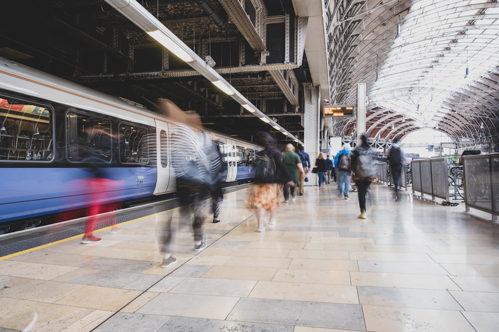 a group of people standing on a platform next to a train