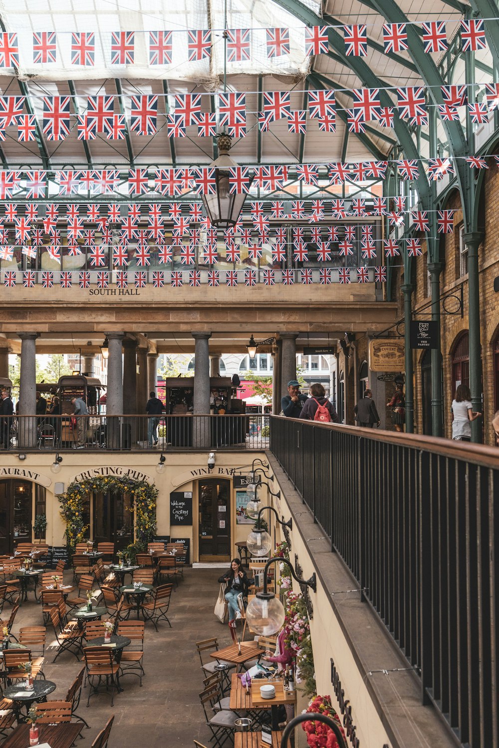 an indoor restaurant with tables and chairs and flags hanging from the ceiling