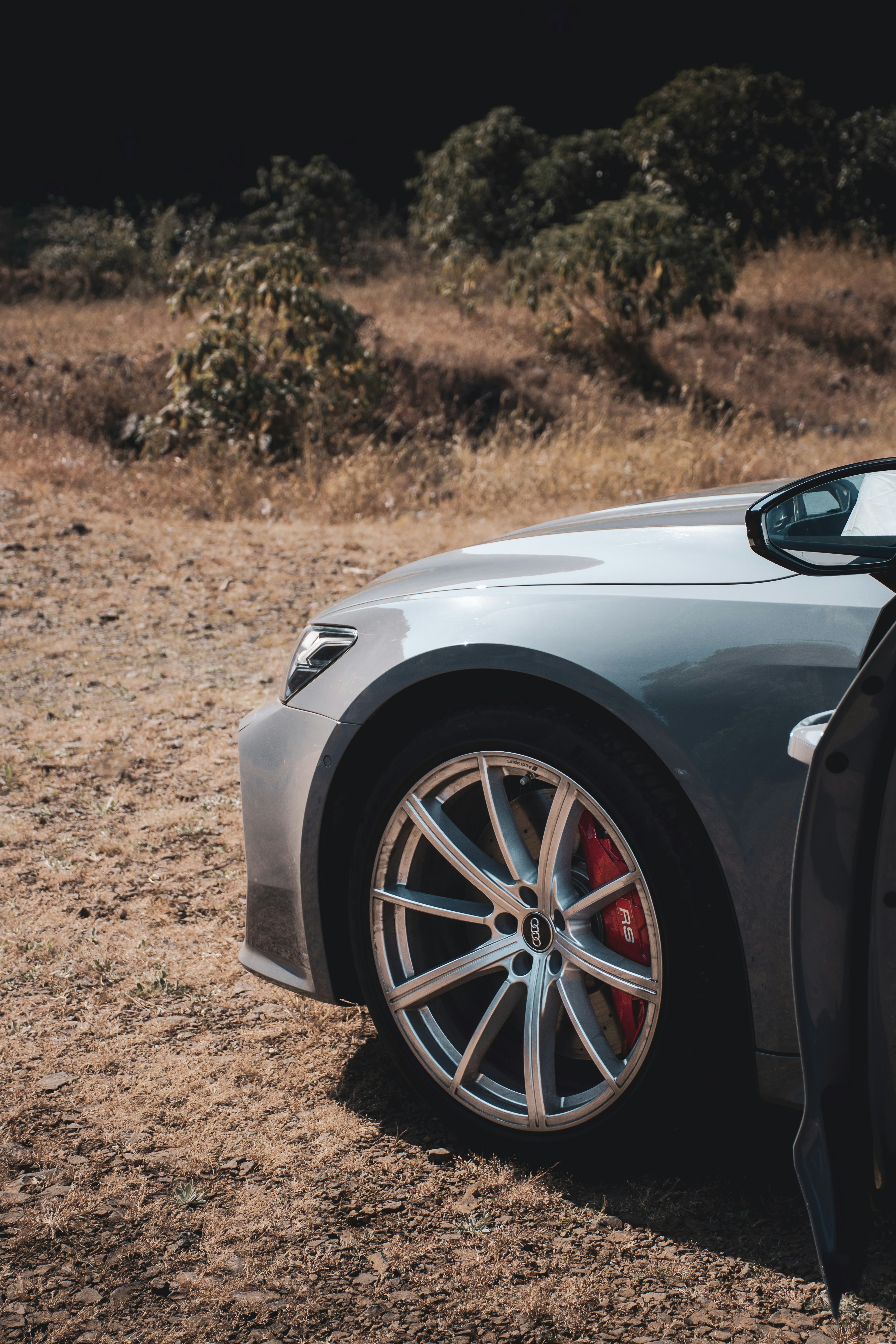 a car parked in a field with its door open