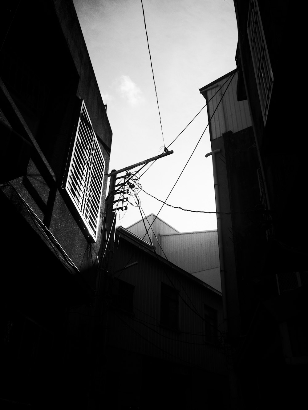 a black and white photo of power lines and buildings