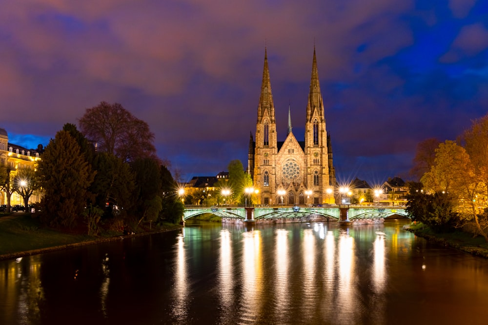 a large cathedral towering over a city next to a river