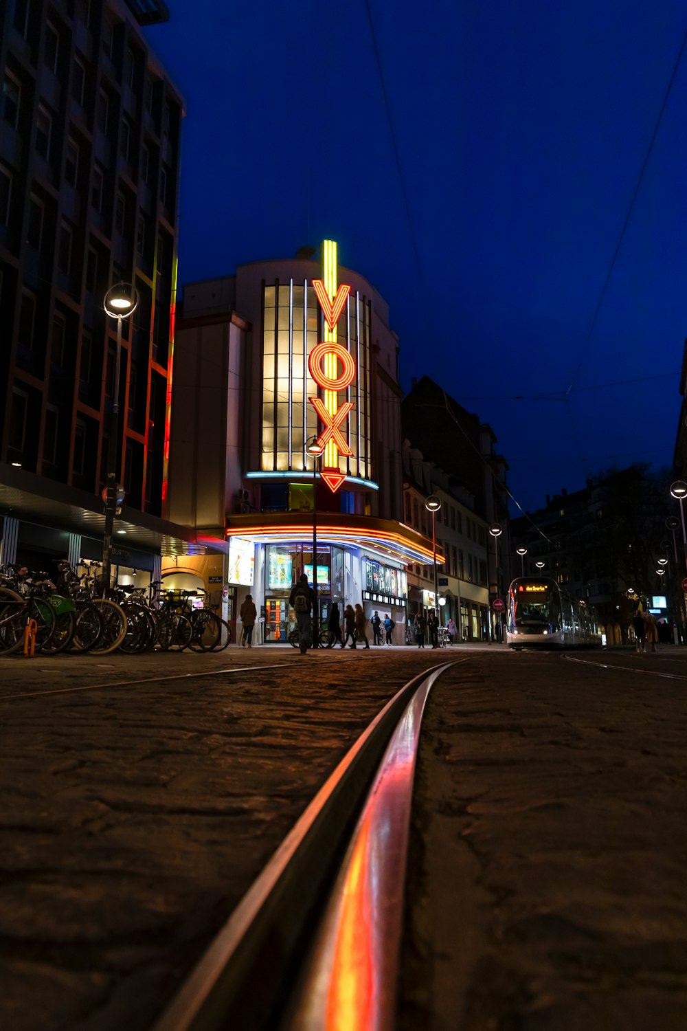 a train track in front of a building at night