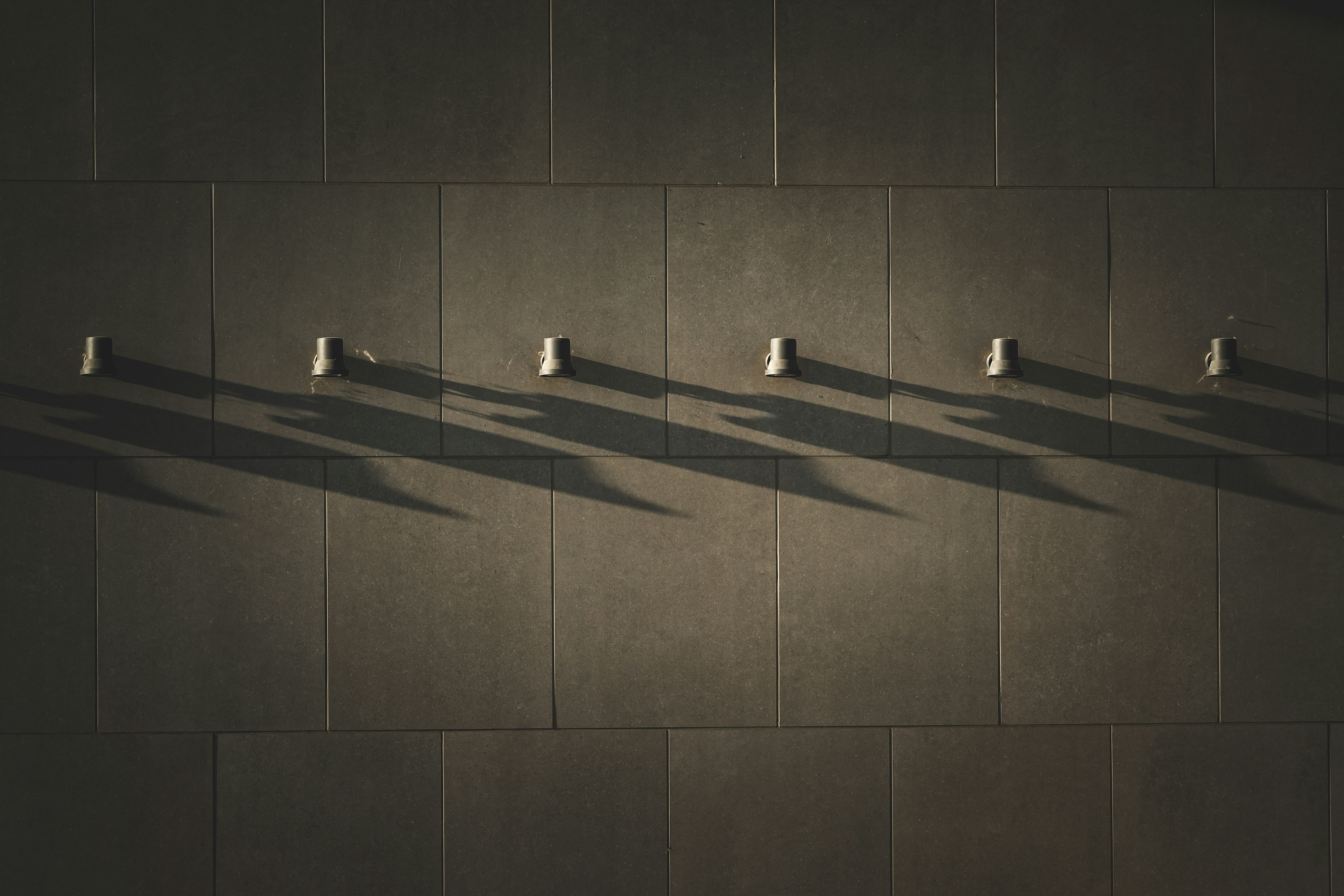a row of white cups sitting on top of a wall