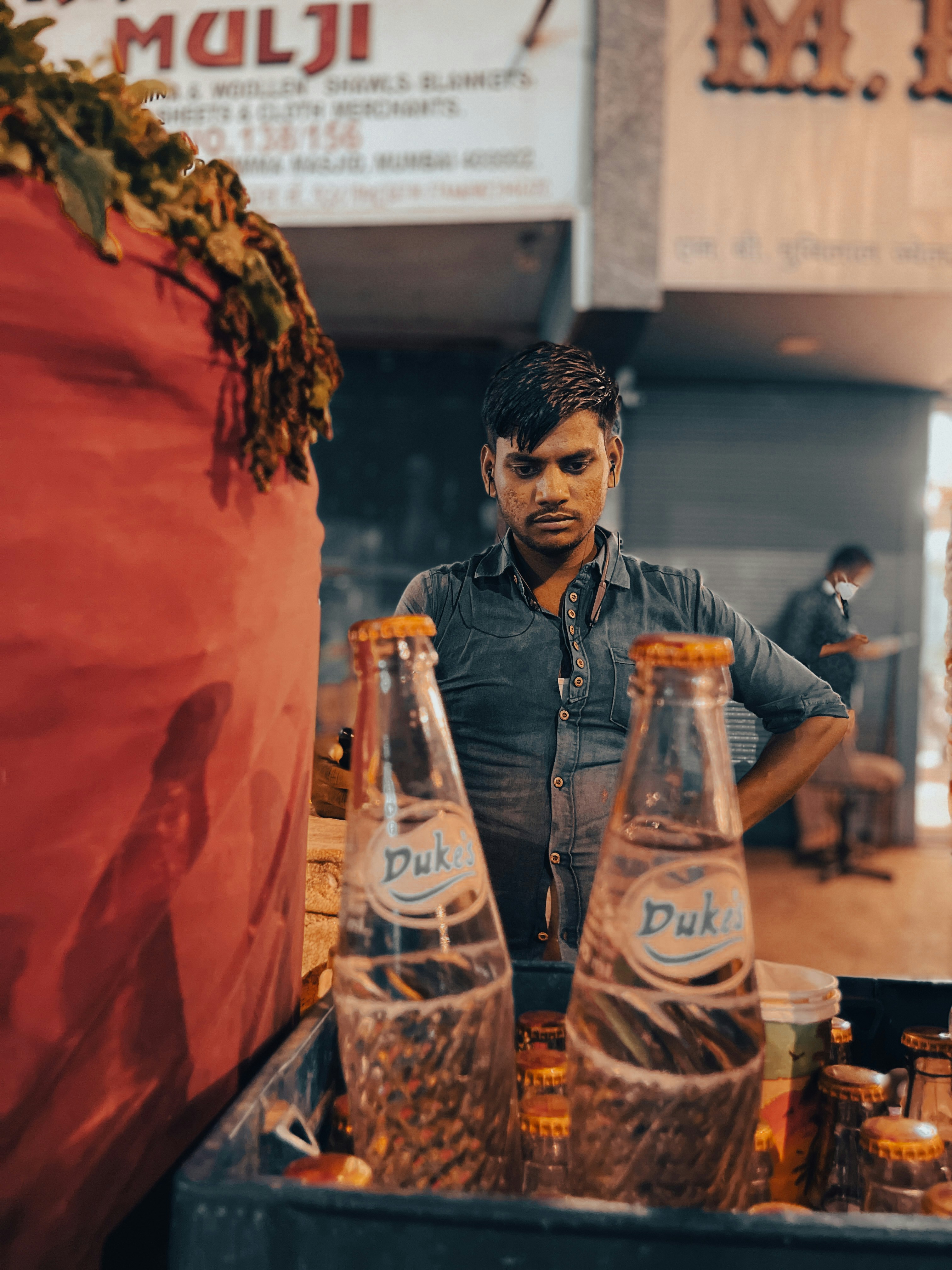 Seorang pria berdiri di depan meja berisi botol